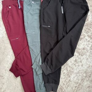 XS Fig scrub pants in burgundy, seafoam green, and black